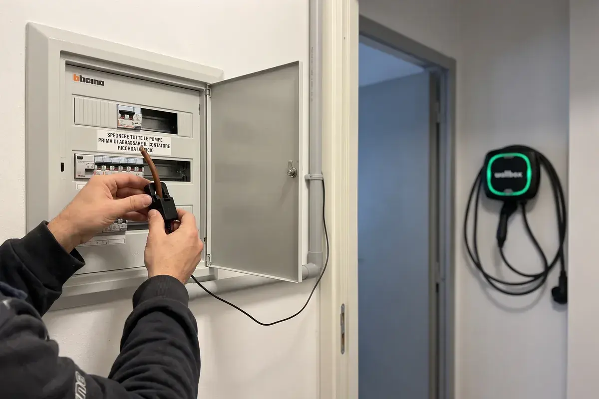 Elettricista che aggancia il sensore di corrente al cavo principale nel quadro BTicino per il bilanciamento dinamico di una Wallbox Pulsar Max.